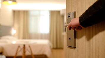 A man opens the door to his hotel room