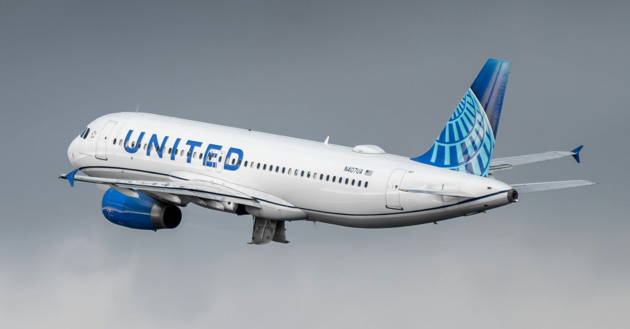 United Airlines plane in mid-flight against a cloudy sky