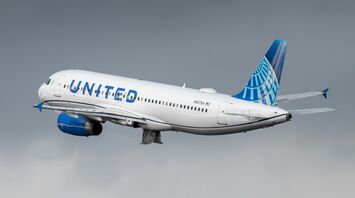 United Airlines plane in mid-flight against a cloudy sky