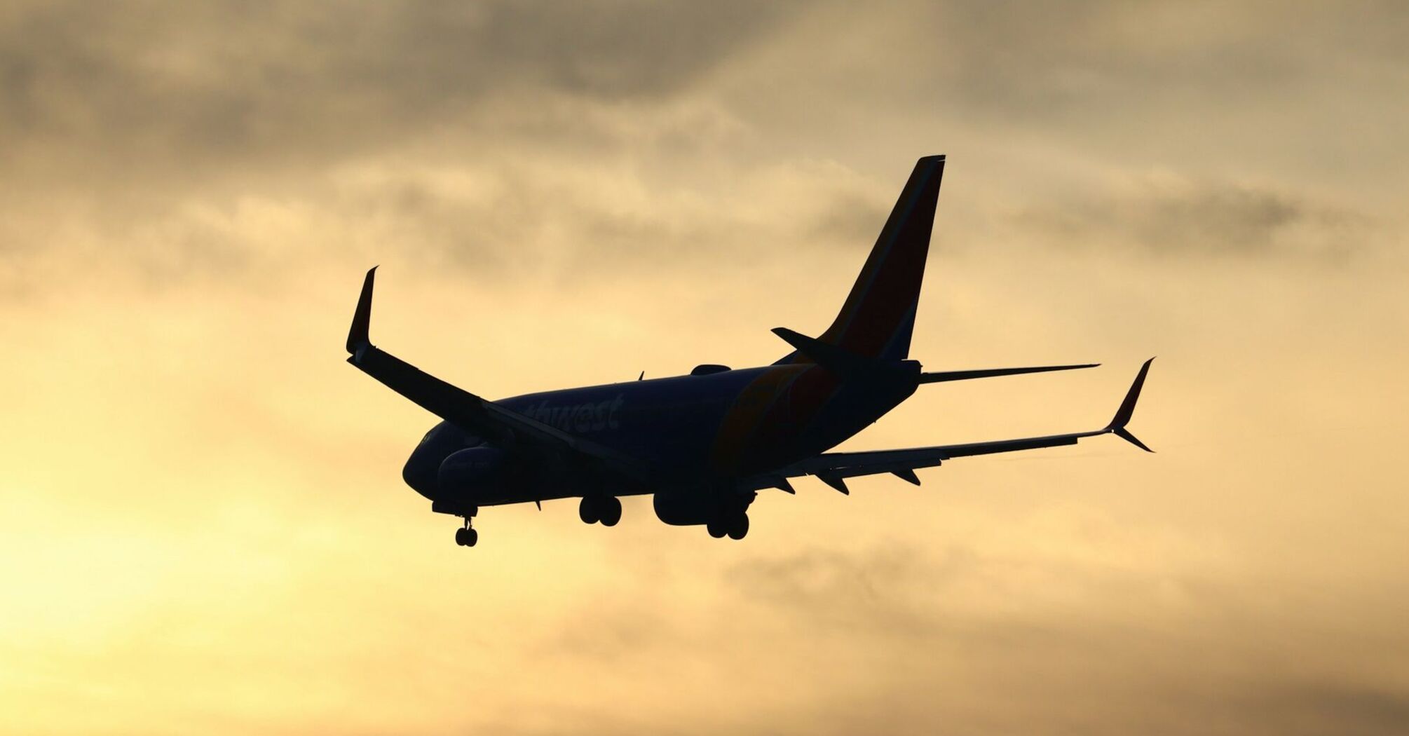 Silhouette of a Boeing 737 in flight at sunset