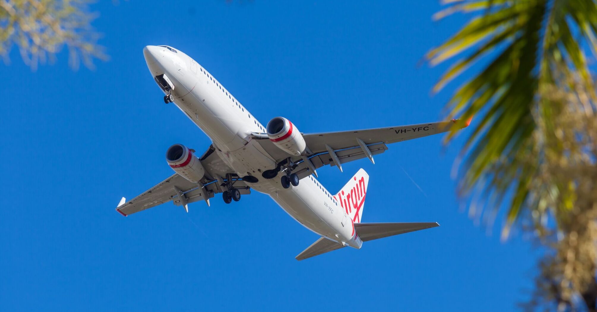 Virgin Australia airplane flying against a clear blue sky