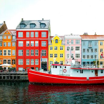 Colorful buildings and a red boat on the waterfront in Copenhagen, Denmark