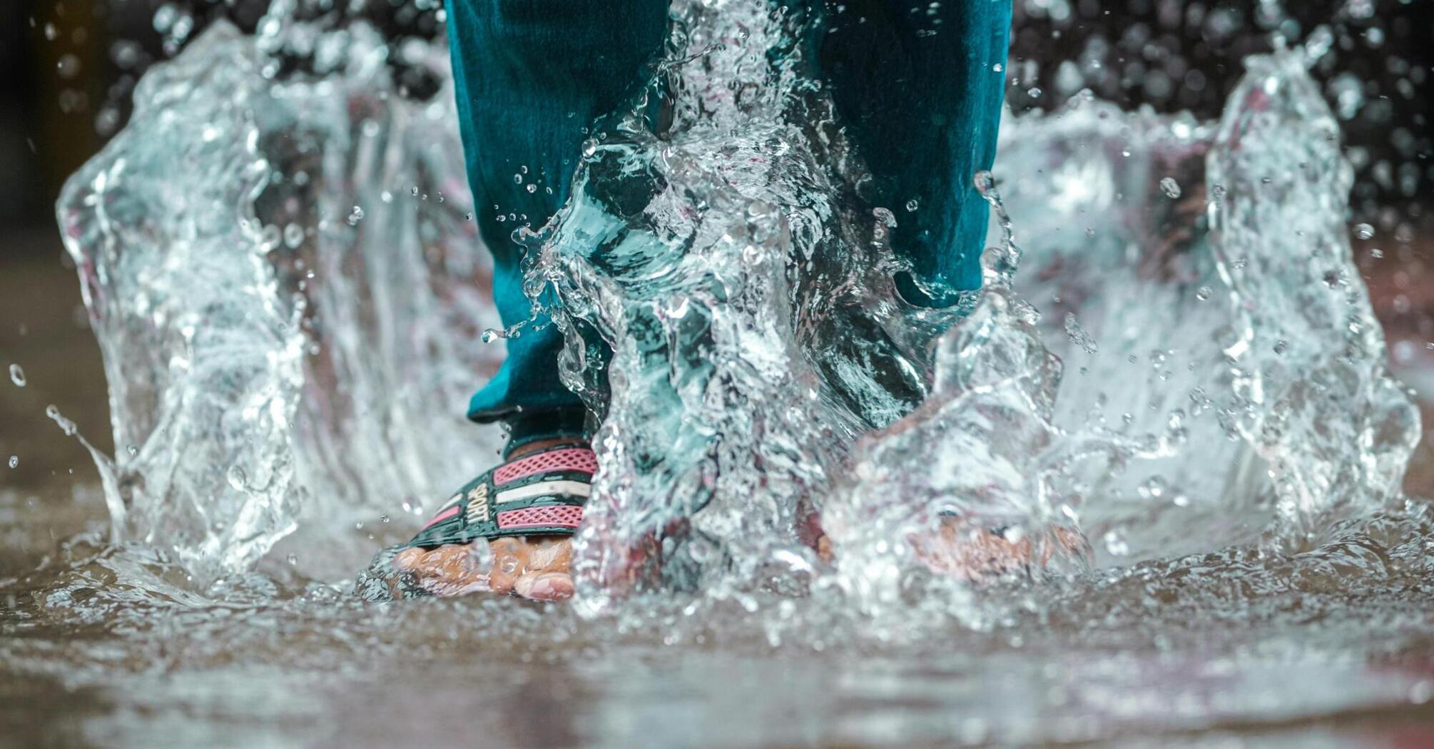 A person walking through puddles during a flood