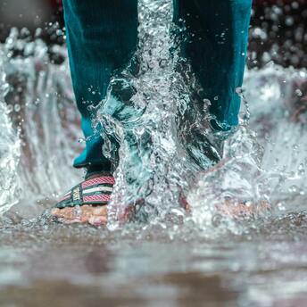 A person walking through puddles during a flood