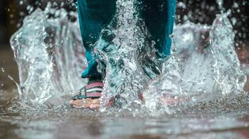 A person walking through puddles during a flood