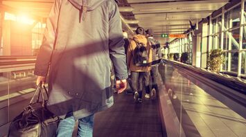 Passenger walking through an airport terminal with luggage