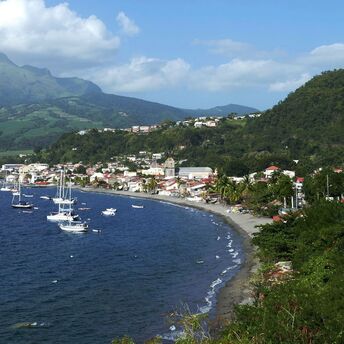 Coastal town in Martinique with boats and mountains in the background