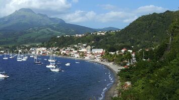 Coastal town in Martinique with boats and mountains in the background