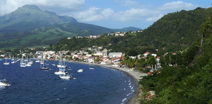 Coastal town in Martinique with boats and mountains in the background