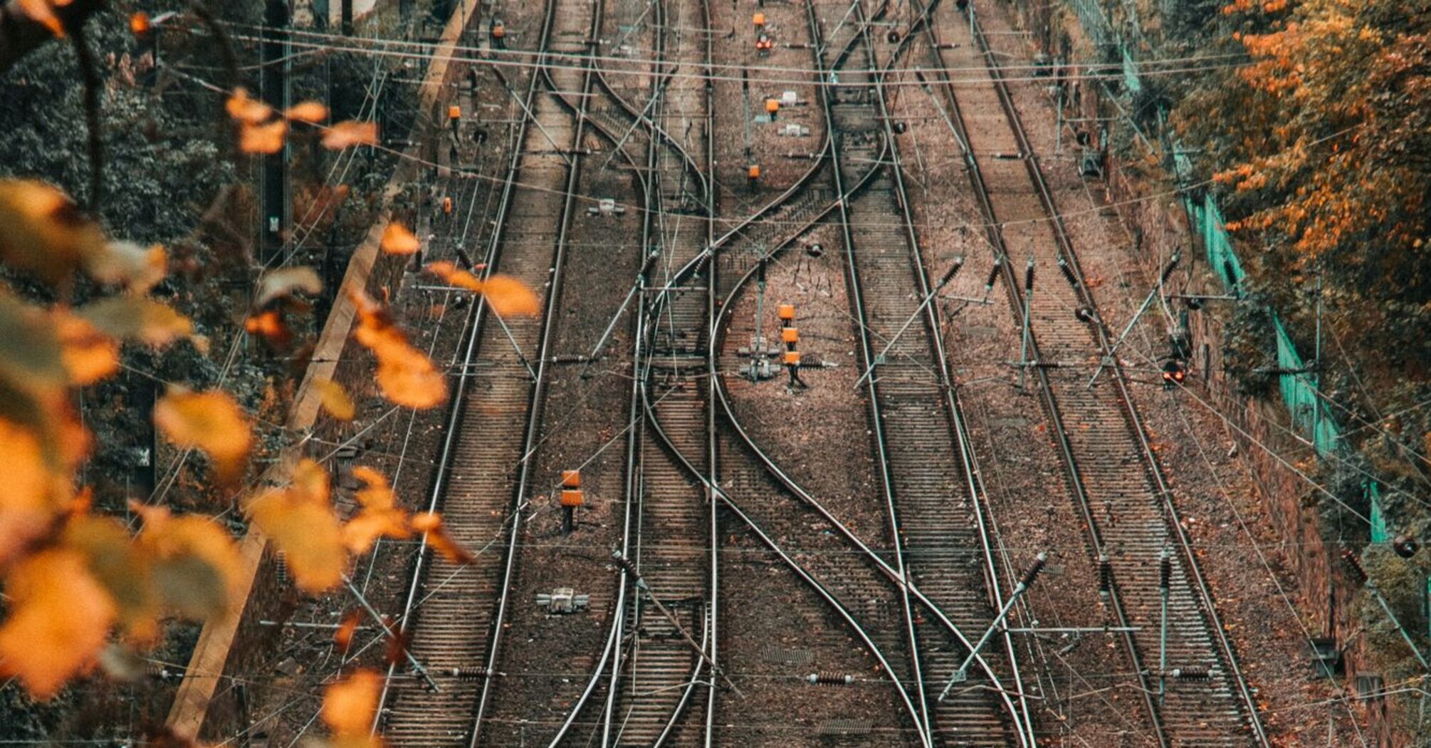 A view of complex railway tracks surrounded by autumn foliage, indicating rail lines prepared for maintenance or repair work