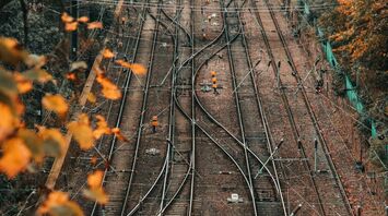 A view of complex railway tracks surrounded by autumn foliage, indicating rail lines prepared for maintenance or repair work