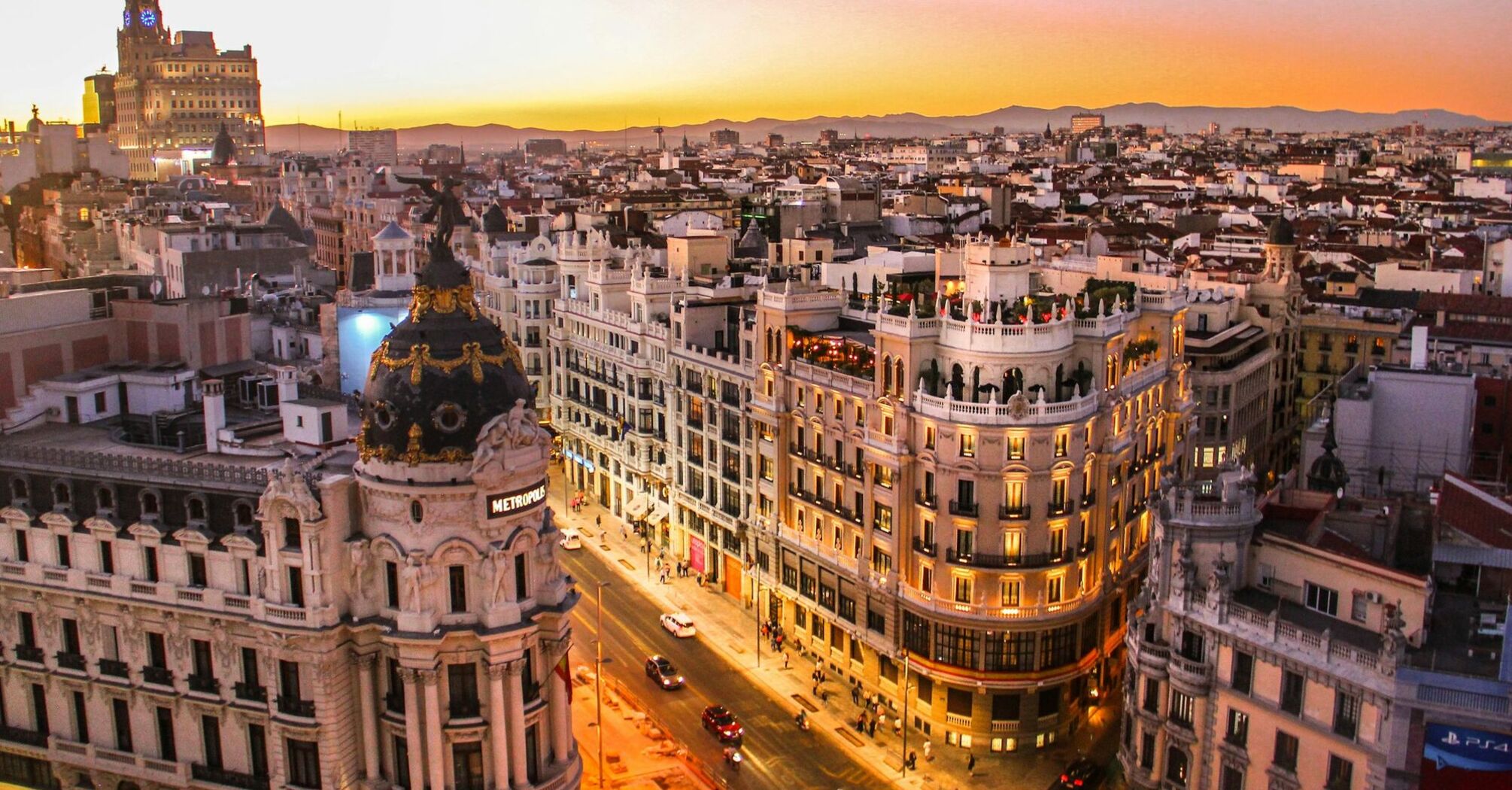 Aerial view of Madrid cityscape at sunset, featuring the Metropolis building and surrounding architecture