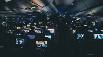 Passengers watching films on in-flight entertainment screens during a night flight