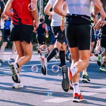 Marathon participants running on city streets with bubbles adding a festive touch