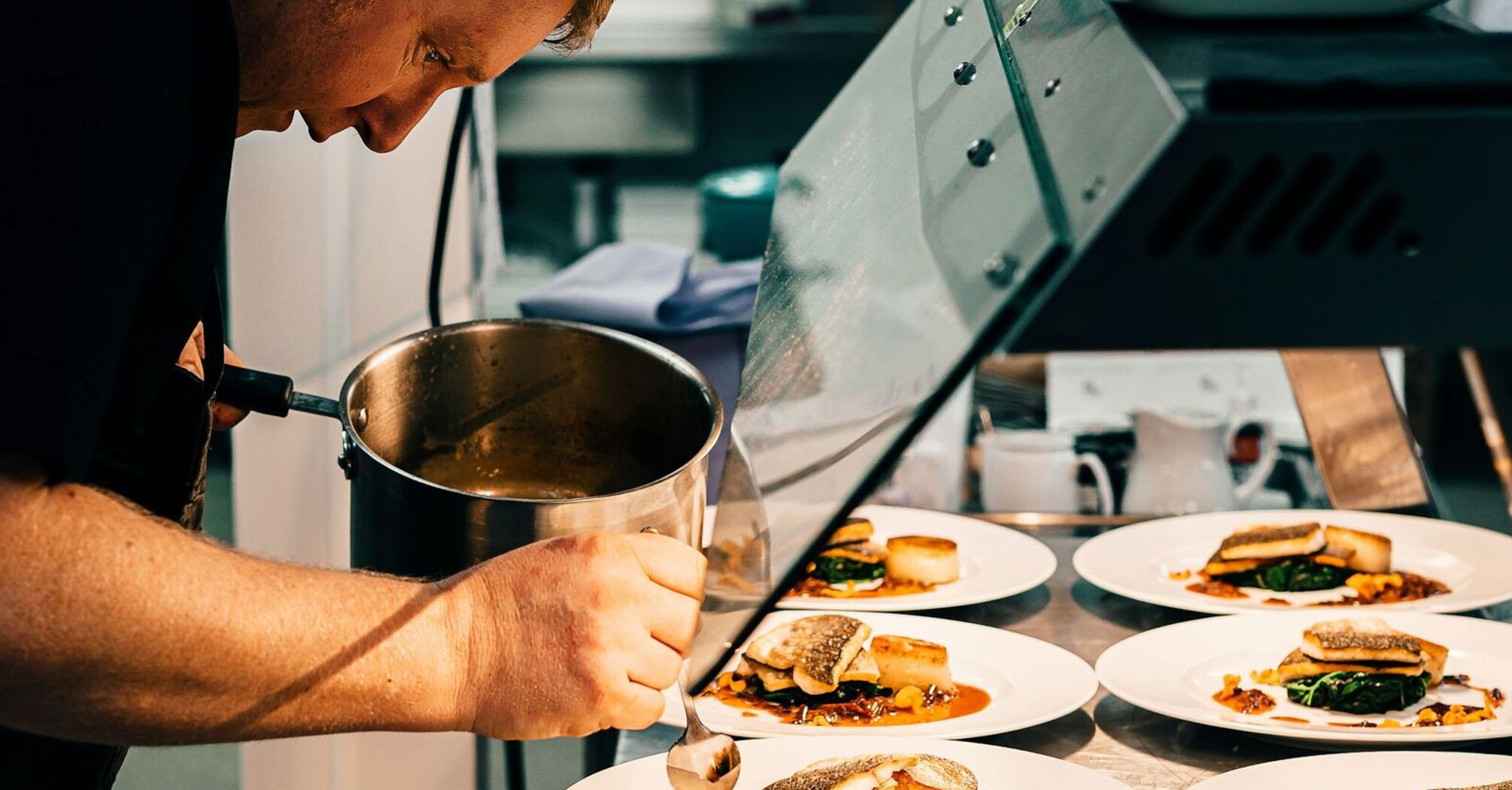 A chef carefully plating gourmet dishes in a professional kitchen