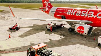 AirAsia aircraft on the tarmac at an airport with ground services
