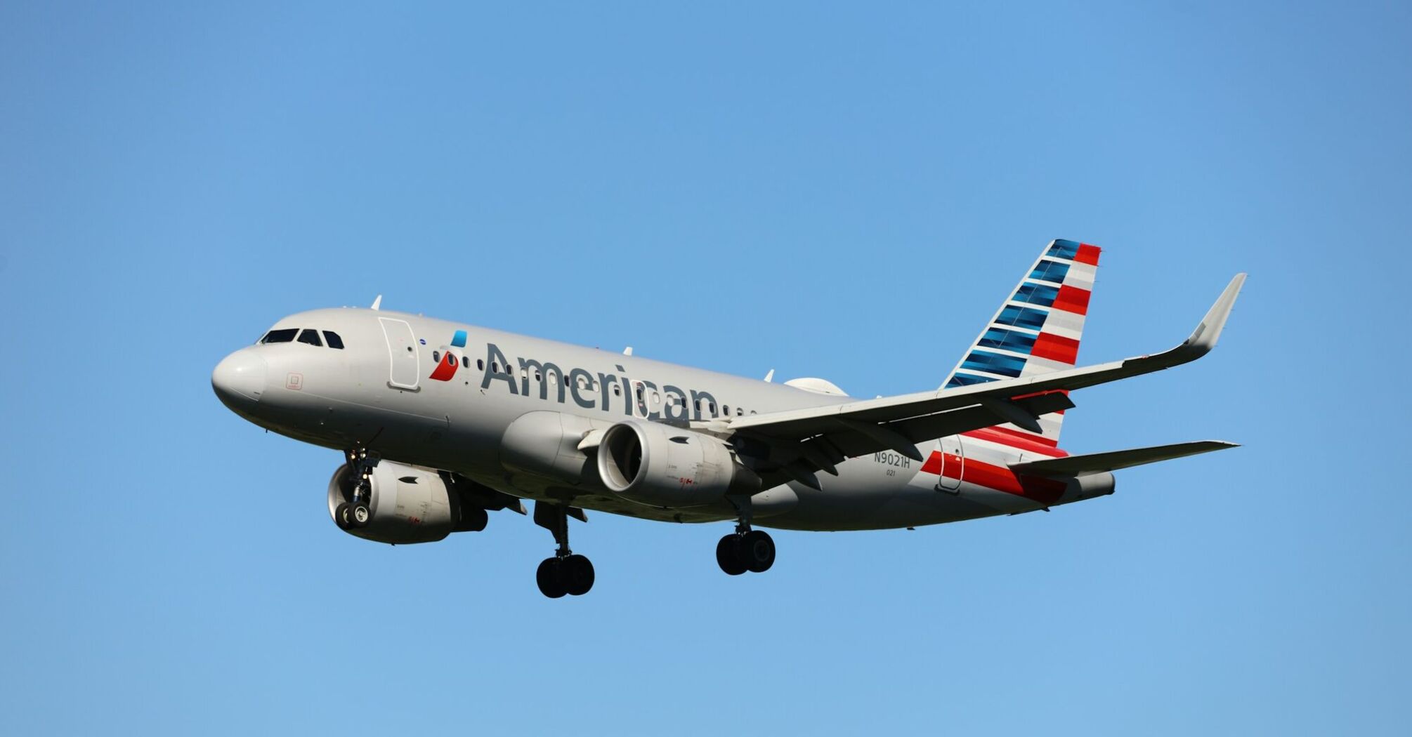 An American Airlines plane flying in clear blue skies