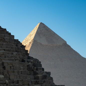 Two ancient pyramids under a clear blue sky in Giza