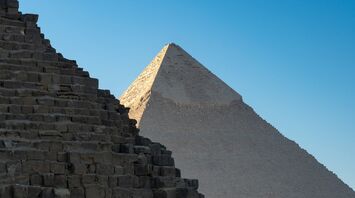 Two ancient pyramids under a clear blue sky in Giza