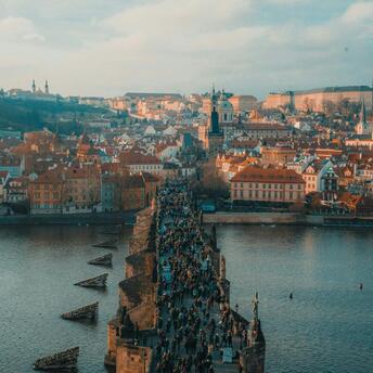 Aerial view of Charles Bridge crowded with tourists and Prague Castle in the background