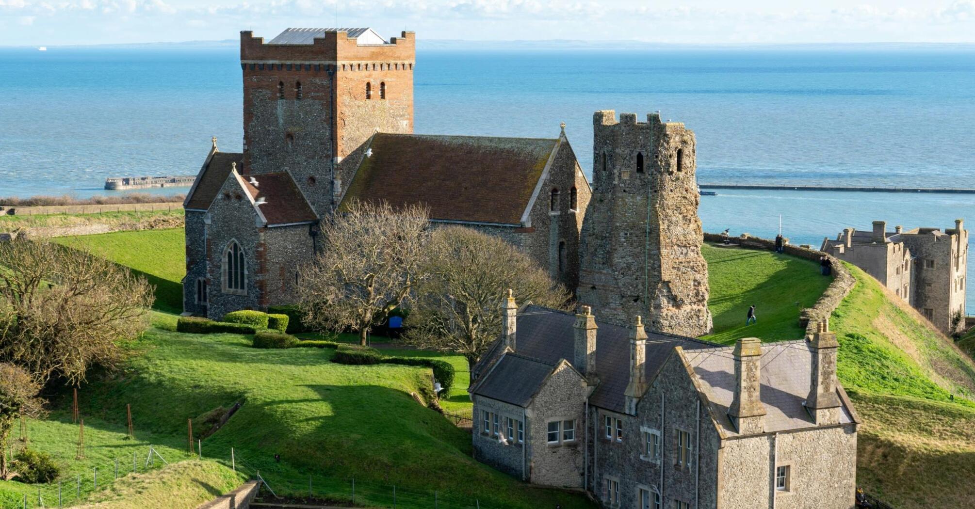 Historic English castle and church overlooking the sea on a sunny day