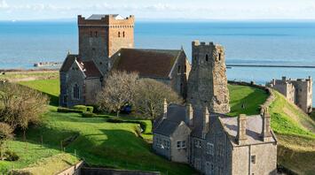 Historic English castle and church overlooking the sea on a sunny day