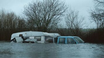 A flooded caravan and vehicle submerged in water after heavy rainfall
