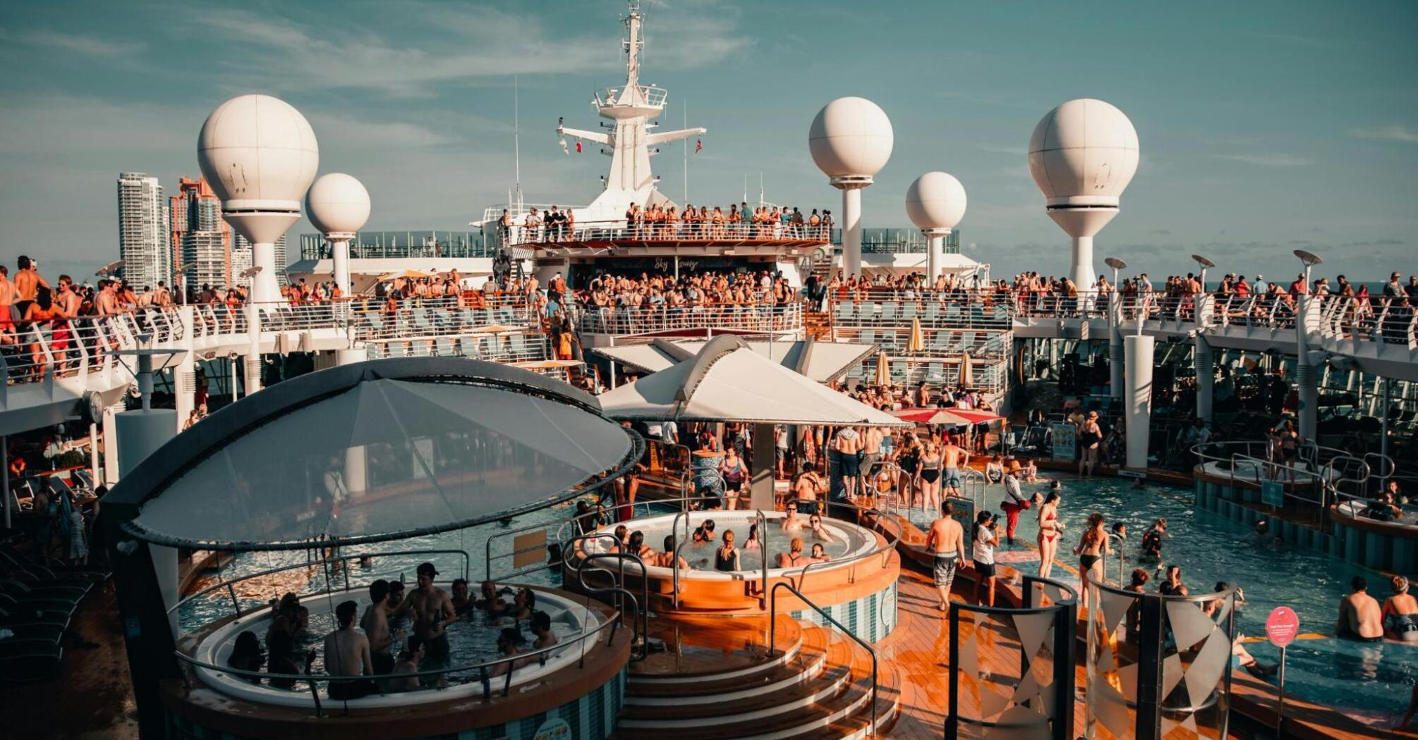 Guests enjoying pools and entertainment aboard a cruise ship during a lively event 