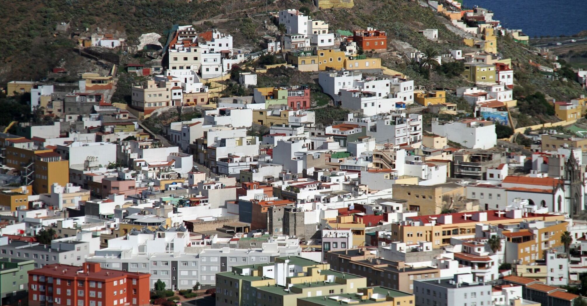 A densely packed residential area on a hillside in the Canary Islands