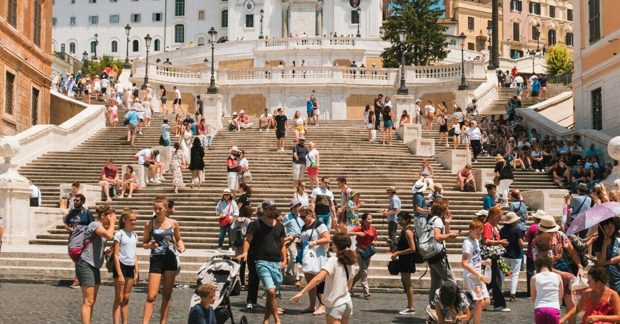 Tourists gathered at the famous Spanish Steps in Rome on a sunny day, enjoying the historical site