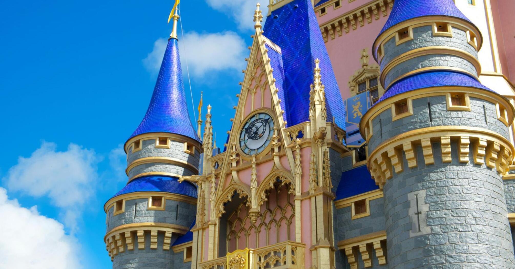 Close-up of a castle with blue towers and gold accents under a clear sky