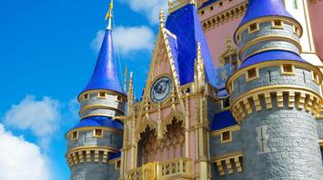 Close-up of a castle with blue towers and gold accents under a clear sky