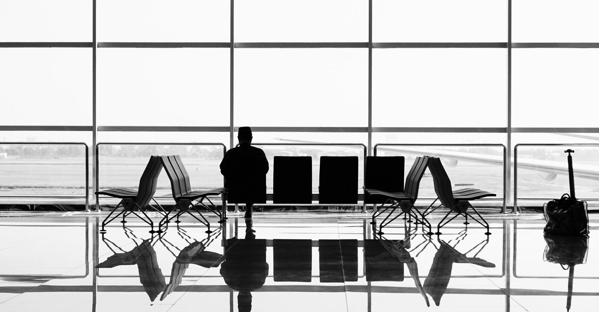 man sitting on gang chair during daytime