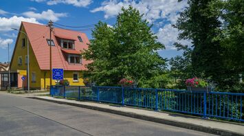 A peaceful town at the French-German border with a yellow house, blue railing, and a European border sign