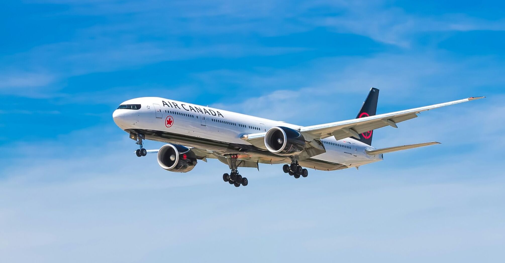 A large Air Canada airplane flying against a blue sky