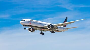 A large Air Canada airplane flying against a blue sky