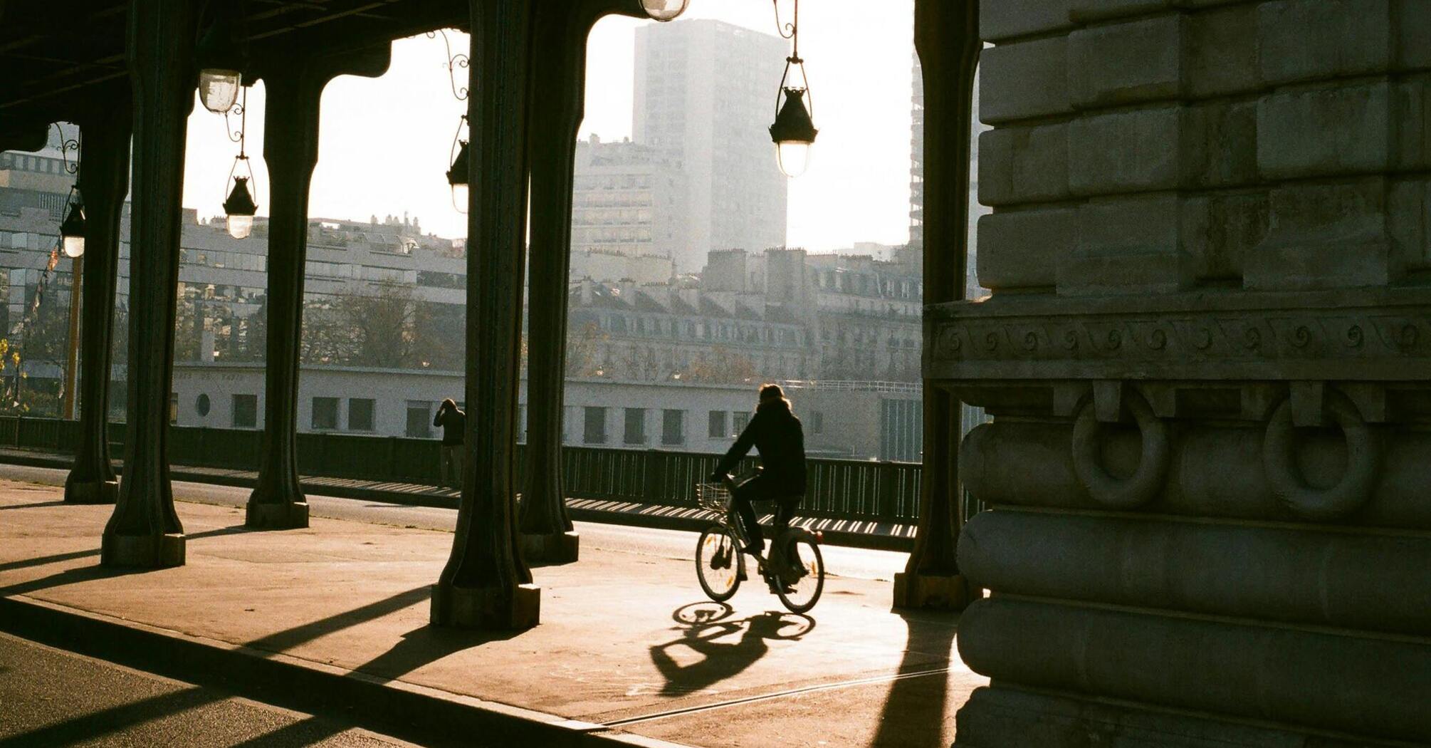 Cyclist riding through an urban bridge in Paris