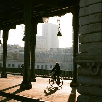 Cyclist riding through an urban bridge in Paris