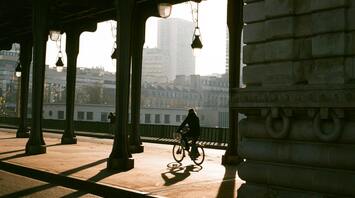 Cyclist riding through an urban bridge in Paris