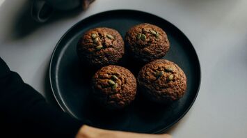 A person enjoying coffee with muffins