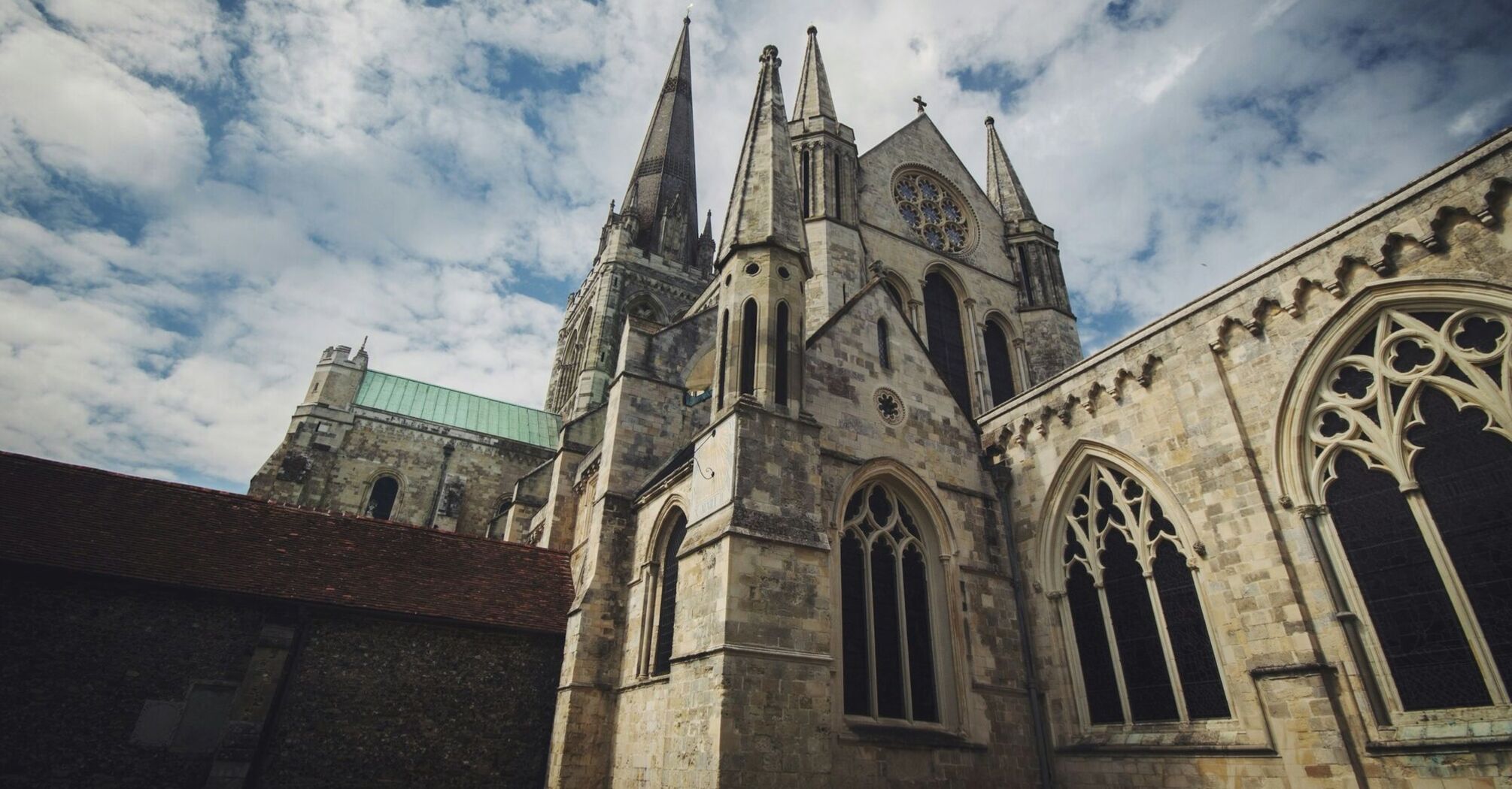 Exterior view of Chichester Cathedral under a partly cloudy sky