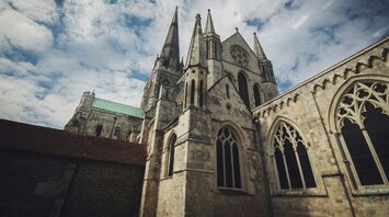 Exterior view of Chichester Cathedral under a partly cloudy sky