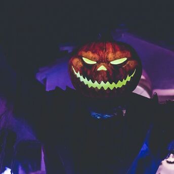 A glowing jack-o'-lantern with an eerie grin illuminated in the dark, creating a spooky Halloween atmosphere