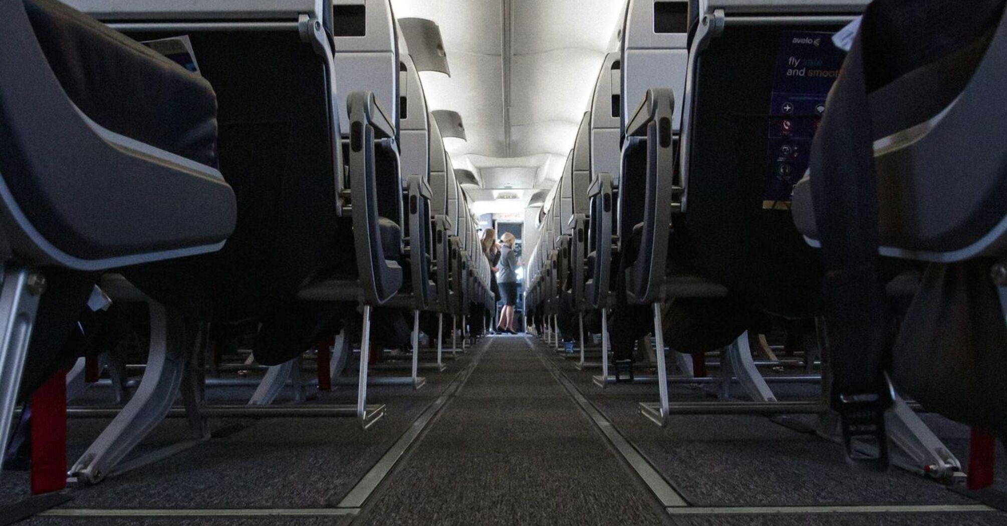 The interior of an Avelo Airlines airplane showing rows of seats with a central aisle