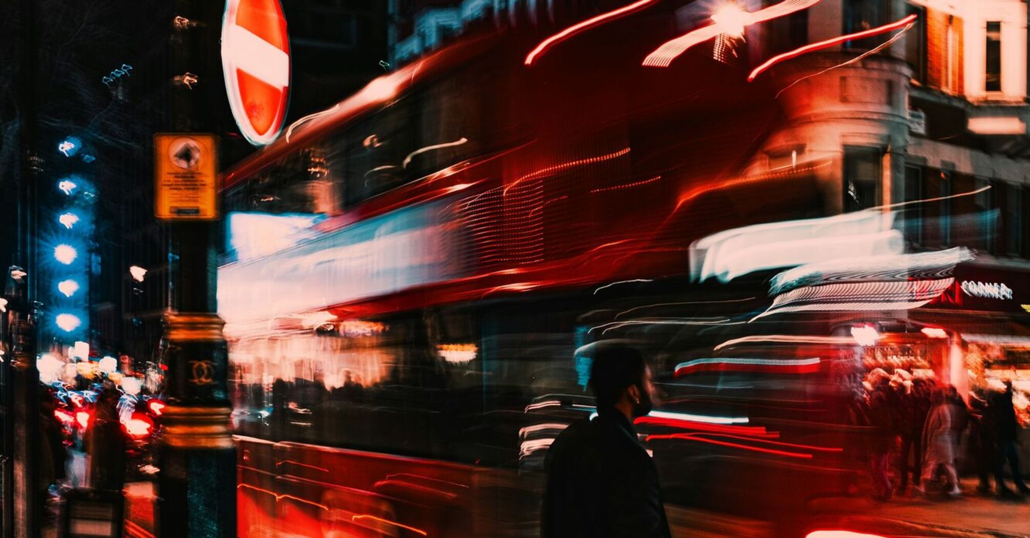 Blurred motion of a double-decker bus at night in a busy city street