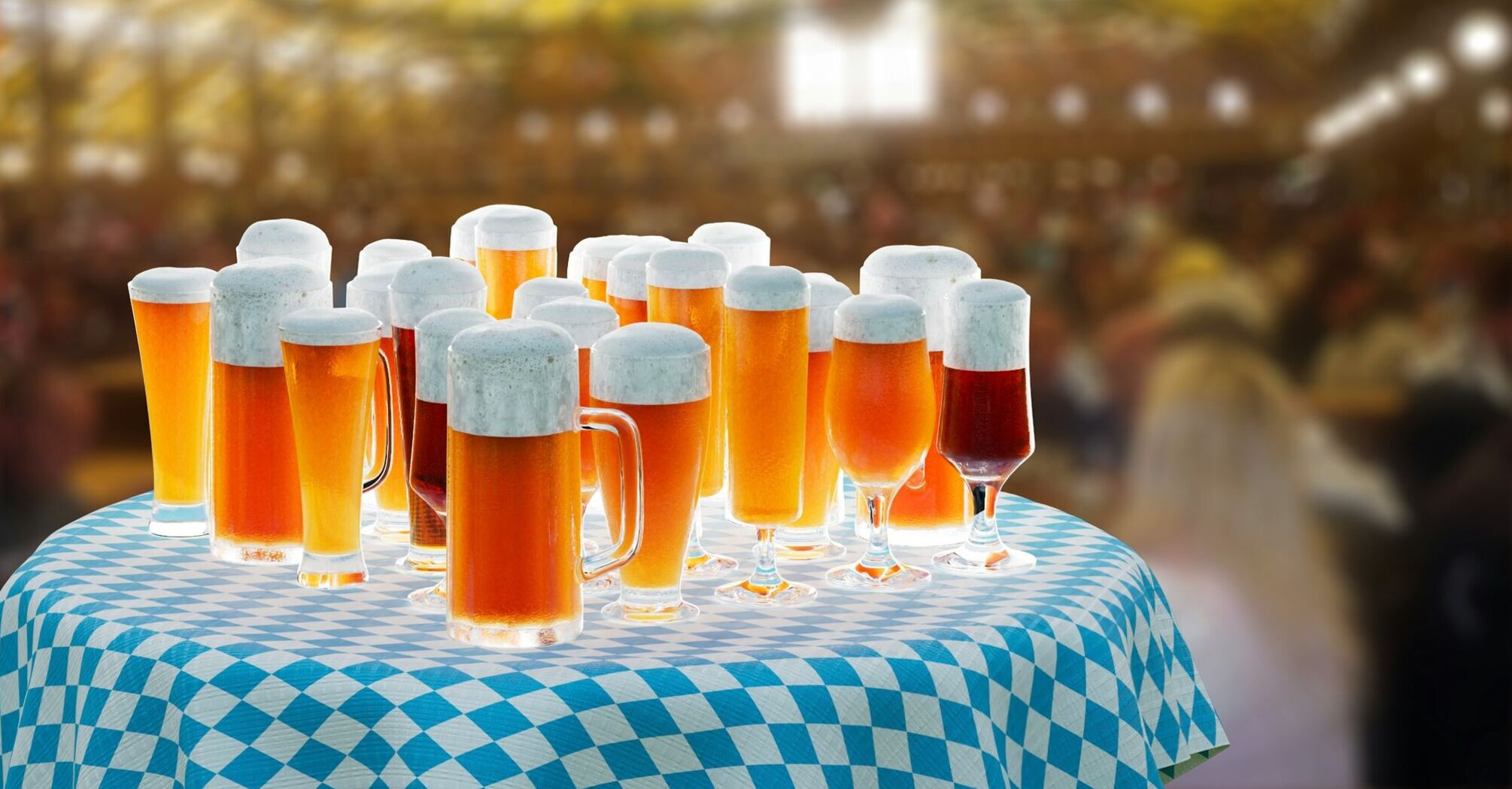 A table filled with glasses of beer under a Bavarian-style tent during Oktoberfest