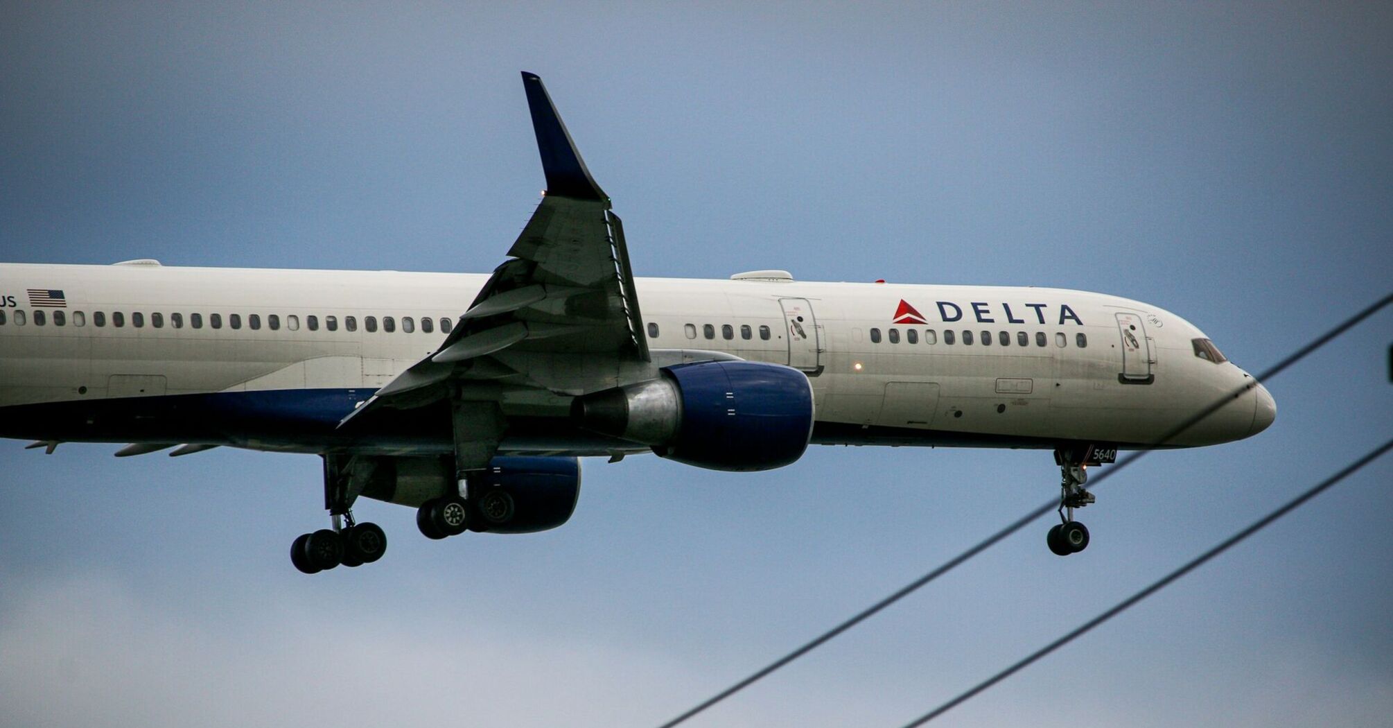 A Delta Air Lines plane approaching for landing, showing its landing gear extended and preparing to touch down