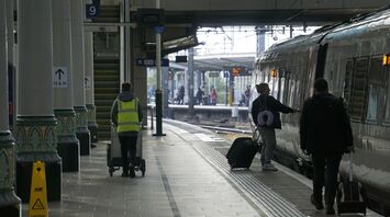 Train platform with passengers boarding and staff working at the station