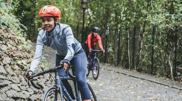 Cyclists riding through a forested path, enjoying an outdoor cycling experience