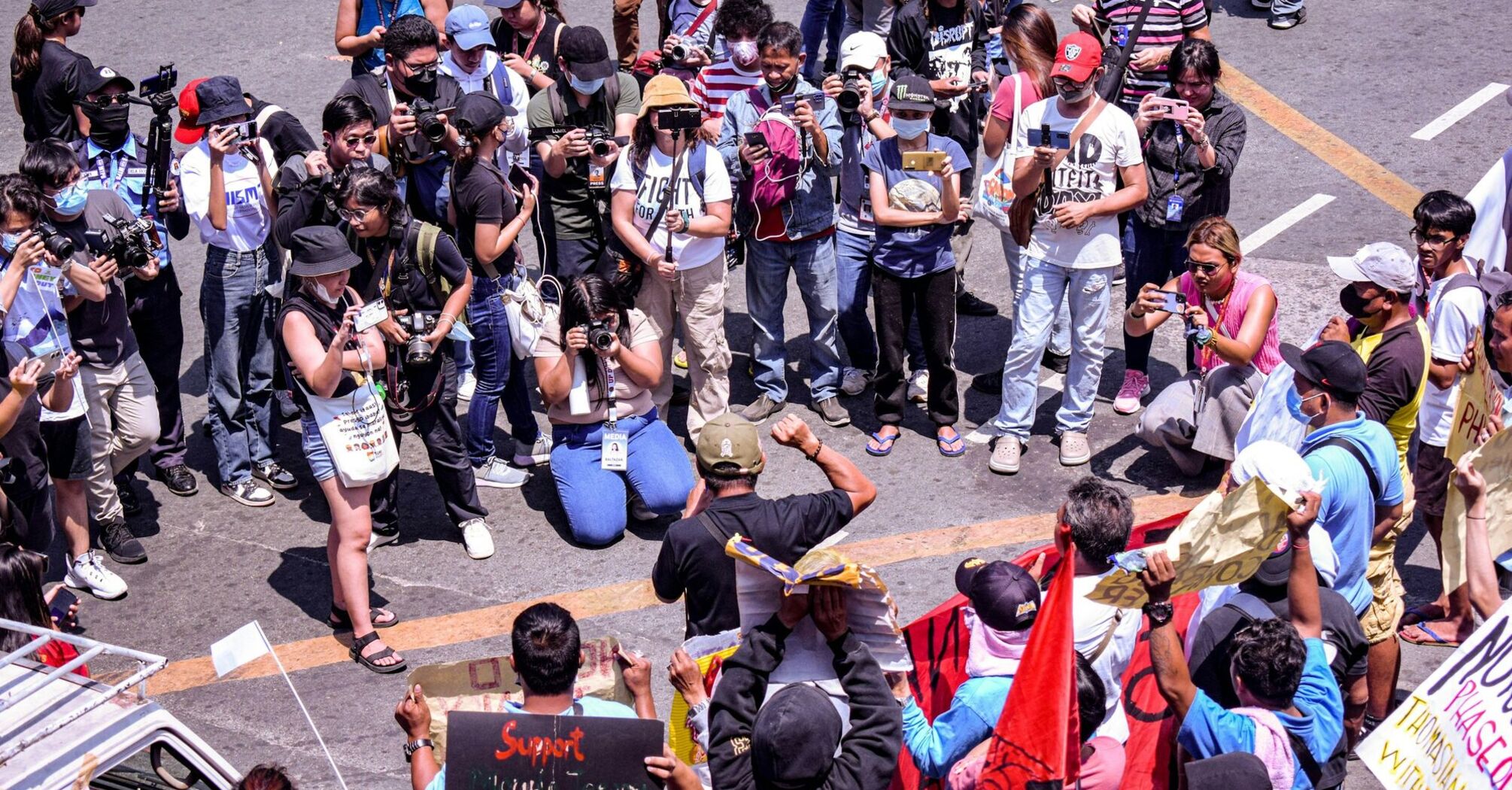 Crowd of protesters and journalists gathered on a city street